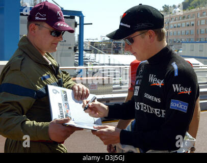 (Afp) - pilote de formule 1 finlandais Kimi Raikkonen de McLaren Mercedes, signe des autographes avant la première session d'essais pour le Grand Prix de Monaco à Monte Carlo, Monaco, 19 mai 2005. Banque D'Images