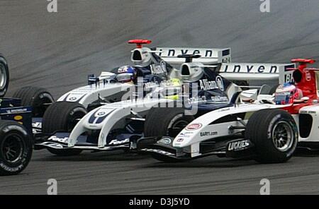 (Afp) - L'allemand Ralf Schumacher pilote de formule 1 de BMW-Williams (C) entre en collision avec son coéquipier colombien Juan Pablo Montoya (retour) dans le premier virage lors de la Grand Prix d'Europe à la piste de course de Nürburgring en Allemagne, le 30 mai 2004. L'accident implique également le Brésil, Christiano da Matta (couverte) de Toyota. (Italie) Banque D'Images