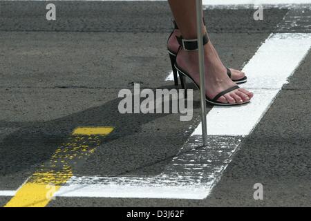 (Afp) - Une grille girl montre une pancarte avec un numéro de départ peu de temps avant le début du Grand Prix sur le Nürburgring en Allemagne, le 30 mai 2004. Banque D'Images