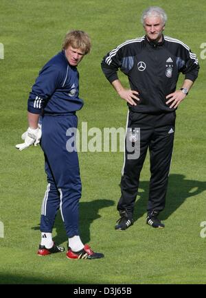 (Afp) - Rudi Voeller (R), entraîneur-chef de l'équipe nationale de football allemande, et le gardien Oliver Kahn se tenir sur le terrain pendant une session de formation à Freiburg, Allemagne, 26 mai 2004. Dans le cadre de leur préparation pour la prochaine Coupe du Monde au Portugal l'équipe allemande rencontrera l'équipe nationale de soccer de Malte dans un jeu de bienfaisance le jeudi 27 mai 2004. Banque D'Images