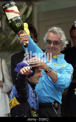 (Afp) - Le chef de l'équipe Renault, Flavio Briatore (R), verse une bouteille de champagne sur la tête de l'Italien Jarno Trulli pilote de formule 1 de Renault après le Grand Prix de Formule 1 de Monaco, le 23 mai 2004. Trulli, qui a commencé sur le pole-position, a remporté le Grand Prix de Monaco et a célébré la première victoire de sa carrière. Banque D'Images