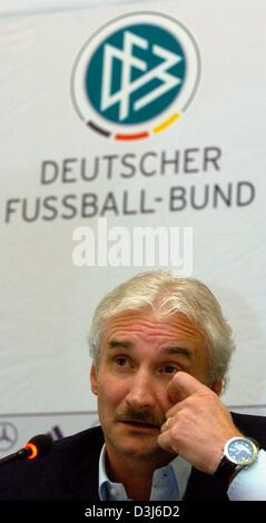 (Afp) - L'entraîneur de soccer national allemand Rudi Voeller parle devant le logo de la fédération de football allemande au cours d'une conférence de presse à Francfort, Allemagne, le lundi 24 mai 2004. Voeller a annoncé les noms des 23 joueurs qui vont jouer dans l'équipe d'Allemagne durant la coupe d'Europe au Portugal. Banque D'Images