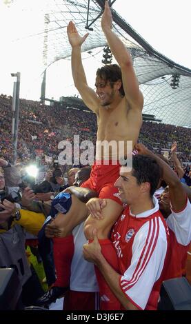 (Afp) - Le milieu de terrain du Bayern Munich Bixente Lizarazu (haut) à la vôtre comme il est mis sur les épaules de ses coéquipiers Sammy Kuffour (L) et Roy Makaay (R) à travers le terrain après le match de football de la Bundesliga contre FC Bayern Munich et SC Freiburg à Munich, Allemagne, 22 mai 2004. Lizarazu quitte le Bayern Munich après avoir joué sept ans pour le club de football de la Bundesliga. Banque D'Images