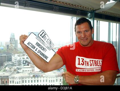 (Afp) - L'acteur hollywoodien allemand Ralph Moeller sourit et pose avec le logo de la nouvelle chaîne de télévision à péage, "13ème Rue" comme il fait la promotion de la nouvelle série télévisée "Action-Lexikon » lors d'une conférence de presse à Berlin, le 13 mai 2004. Moeller, qui présentera la série, révèle les astuces et fonds derrière des cascades et scènes d'action dans les films. Banque D'Images