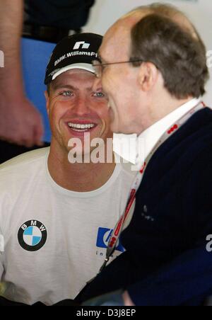 (Afp) - L'allemand Ralf Schumacher pilote de formule 1 de BMW-Williams sourire alors qu'il discute avec son chef d'équipe Frank Williams au cours de la première formation gratuite au circuit de Formule 1 à Barcelone, Espagne, le 7 mai 2004. Schumacher conduit le sixième meilleur temps. Le grand prix va avoir lieu ce week-end du 8 mai et 9 mai 2004. Banque D'Images