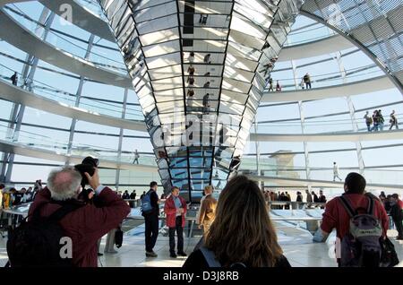 (Afp) - un visiteur prend une photo sous le grand dôme en verre du Reichstag allemand à Berlin, Allemagne, 15 avril 2004. Il y a cinq ans, le 19 avril 1999, l'ancien bâtiment du Reichstag a été rouvert en tant que le nouveau Bundestag (Parlement allemand) après une rénovation de 307 millions d'euros et huit ans après le gouvernement allemand avait décidé de déménager de l'ancienne capitale de Bonn à Berlin Banque D'Images