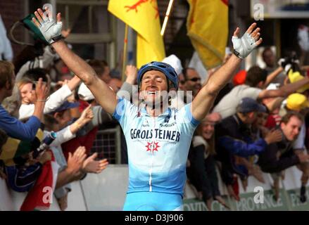 (Afp) - L'Italien Davide Rebellin de Pro Cycling Team Gerolsteiner soulève ses bras et encouragements aux yeux clos après avoir remporté la 5e manche de la coupe du monde à Liège, Belgique, 25 avril 2004. 32-year-old Rebellin remporte sa troisième coupe du monde d'affilée et le tricot blanc de la coupe du monde l'avant-coureur. La course de distance couverte 258,5 kilomètres de Liège à Bastogne et retour. Banque D'Images