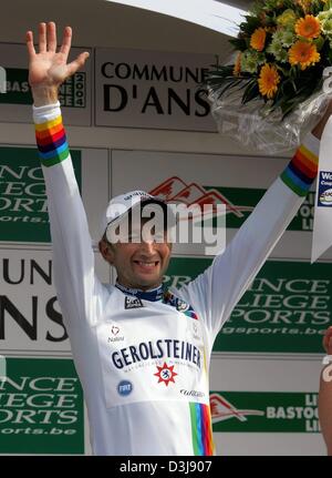 (Afp) - L'Italien Davide Rebellin de Pro Cycling Team Gerolsteiner soulève ses bras et après avoir remporté la 5ème cheers course de la série de la coupe du monde à Liège, Belgique, 25 avril 2004. 32-year-old Rebellin remporte sa troisième coupe du monde d'affilée et le tricot blanc de la coupe du monde l'avant-coureur. La course de distance couverte 258,5 kilomètres de Liège à Bastogne et retour. Banque D'Images