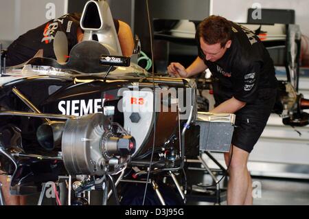 (Afp) - Deux McLaren-Mercedes travail mécanique sur un moteur à la piste de course "Enzo e Dino Ferrari à Imola, Italie', 22 avril 2004. La première course européenne de la saison de F1 aura lieu à Imola avec le Grand Prix de Saint-Marin dimanche prochain. Banque D'Images