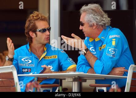 (Afp) - Flavio Briatore, chef d'équipe de Renault, est impliqué dans une discussion avec son pilote italien Jarno Trulli (L) dans la course de Formule Un à Manama, Bahreïn, le 2 avril 2004. Banque D'Images