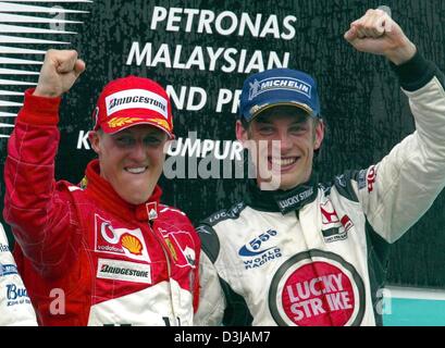 (Afp) Le champion du monde de F1 allemand Michael Schumacher (Ferrari) pose avec la troisième pilote de F1 Jenson Button (BAR-Honda/droit) après avoir remporté le Grand Prix de Malaisie sur le circuit de Sepang près de Kuala Lumpur le dimanche, 21 mars 2004. Schumacher a gagné sa deuxième victoire dans la deuxième course de la saison avec une victoire finale début invulnérables. Banque D'Images