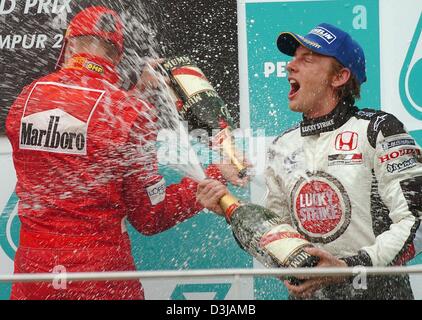 (Afp) Le champion du monde de F1 allemand Michael Schumacher (Ferrari) et troisième pilote de F1 britannique placé Jenson Button (BAR-Honda/gauche) avec d'autres chaque pulvérisation champagne après Schumacher remporte le Grand Prix de Malaisie sur le circuit de Sepang près de Kuala Lumpur le dimanche, 21 mars 2004. Schumacher a gagné sa deuxième victoire dans la deuxième course de la saison avec une victoire finale début invulnérables. Banque D'Images