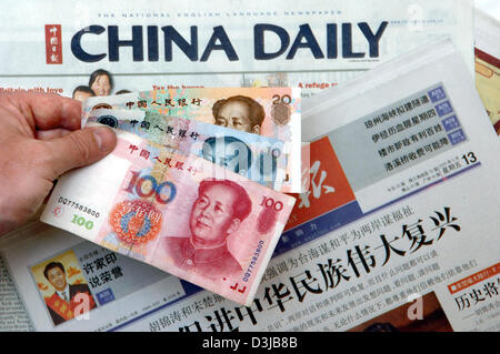 (Afp) - l'image montre une main tenant une banque chinoise note sur les journaux chinois à Beijing, Chine, le vendredi 13 mai 2005. La Banque centrale chinoise a refusé l'augmentation de rumeurs au sujet de la réévaluation de sa monnaie dans les semaines à venir. Selon l'agence de presse officielle chinoise Xinhua de Beijing Gouverneur Zhou Xiaochuan a appelé les spéculations sur un fondement d'une réévaluation de la devise ru Banque D'Images