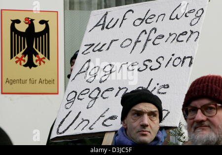 (Afp) - des manifestants chômeurs tenir des panneaux lors d'un rassemblement contre la nouvelle législation du travail 'Hartz IV' en face de l'office de l'emploi dans la région de Francfort, Allemagne, le 3 janvier 2005. Un grand groupe de manifestants s'est joint à la manifestation. Sous le slogan "Agenturschluss" (bureau) d'arrêt visant des manifestants pour protester contre l'injustice sociale dans au moins 81 villes allemandes. Banque D'Images