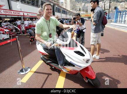 (Afp) - pilote de Formule 1 allemand Ralf Schumacher de la Toyota Racing team se déplace sur un scooter à travers les stands sur la piste à Monte Carlo, Monaco, le mercredi 18 mai 2005. Le Grand Prix de Monaco aura lieu le dimanche 22 mai 2005. Banque D'Images