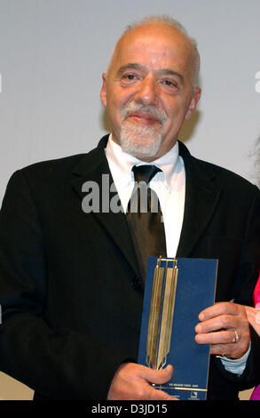 (Afp) - L'auteur brésilien Paulo Coelho a sa récompense dans ses mains après la cérémonie de remise des prix de la chambre de commerce de Hambourg, Allemagne, 19 mai 2005. Coelho a reçu la "Goldene Feder' (golden feather) prix dans la catégorie 'prix honorifique', qui est attribué par l'Heinrich-Bauer maison d'édition. Banque D'Images