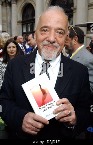 (Afp) - auteur brésilien Paulo Coelho tient son dernier roman "Le Zahir" dans ses mains et sourit comme il arrive pour la cérémonie de remise des prix de la chambre de commerce de Hambourg, Allemagne, 19 mai 2005. Coelho a reçu la "Goldene Feder' (golden feather) prix dans la catégorie 'prix honorifique', qui est attribué par l'Heinrich-Bauer maison d'édition. Banque D'Images