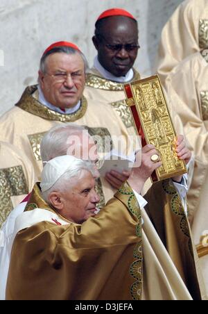 (Afp) - Le pape Benoît XVI est à côté d'cardinal Lehman (L'arrière), tout en tenant une bibel au-dessus de sa tête pendant un service religieux sur la Place Saint Pierre au Vatican, à Rome, Italie, 24 avril 2005. Le pape Benoît XVI a été nommé le nouveau chef de l'église catholique romaine, aujourd'hui, le dimanche 24 avril 2005, Banque D'Images