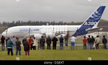 (Afp) - Les spectateurs regardent le prototype du nouvel Airbus A380 roule en travers de la piste à l'aéroport de Toulouse, France, le vendredi 22 avril 2005. Le nouveau Super-Airbus A380 est en cours de préparation pour son premier vol d'essai après une série d'essais sur terrain. La date précise pour le vol d'essai seront sans doute décidé lundi, 25 avril 2005, la porte-parole a déclaré à Airbus Banque D'Images