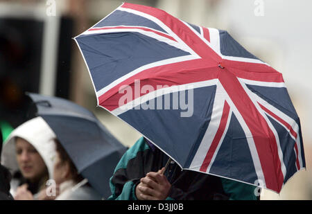 (Afp) - Un homme est titulaire d'un Union Jack-design parasol à Windsor, en Angleterre, 6 avril 2005. Le Prince Charles et son partenaire à long terme de Camilla Parker Bowles mariés dans une courte cérémonie à Windsor le 9 avril 2005. Banque D'Images