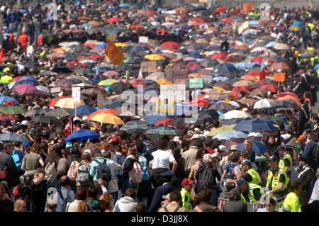 (Afp) - plusieurs milliers de personnes se tenir sous les parasols à des températures autour de 20 degrés celsius pendant l'attente en face de la Basilique Saint Pierre au Vatican, État de la Cité du Vatican, le 6 avril 2005. Jusqu'au 8 avril, la cathédrale a été ouverte jour et nuit pour les visiteurs du monde entier de sorte qu'ils étaient en mesure de payer leur rendre hommage au défunt pape Jean-Paul II. Banque D'Images