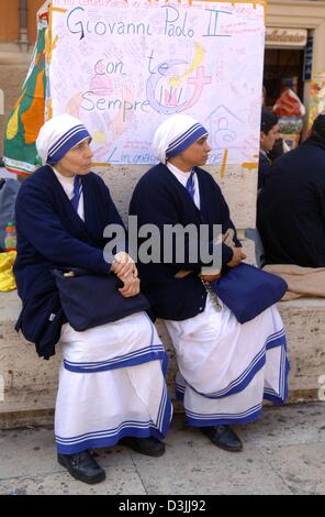 (Afp) - Deux religieuses s'asseoir sur un banc à la place Saint Pierre au Vatican, État de la Cité du Vatican, le 6 avril 2005. Pèlerins du monde entier ont attendu jusqu'à neuf heures pour voir le Pape Jean Paul II qui a été exposé dans la Basilique Saint-Pierre jusqu'à ses funérailles, le 8 avril. Banque D'Images