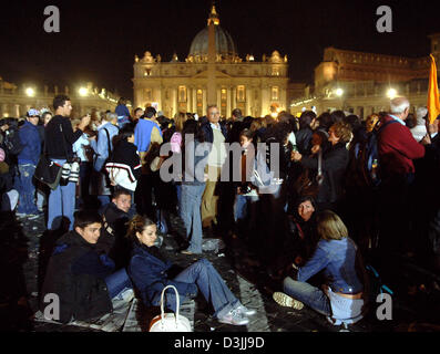 (Afp) - s'asseoir derrière l'épuisement des fidèles foule à la rue en face de la Place Saint Pierre au Vatican, État de la Cité du Vatican, dans la nuit au 6 avril 2005. Jusqu'au 8 avril, la Basilique Saint Pierre est ouverte jour et nuit pour les visiteurs du monde entier de sorte qu'ils étaient en mesure de payer leur rendre hommage au défunt pape Jean-Paul II. Banque D'Images