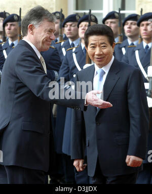 (Afp) - Le président allemand Horst Koehler (L) les gestes pour le président de la République de Corée, M. Roh Moo Hyun, comme ils passent les gardes d'honneur de la Bundeswehr au château de Charlottenburg à Berlin, 11 avril 2005. Roh Moo Hyun et sa femme payer une visite de cinq jours en Allemagne. Banque D'Images