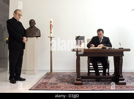 (Afp) - Le Chancelier allemand Gerhard Schroeder signe le livre de condoléances pour le Pape Jean Paul II alors que Erwin Josef Ender Nonce se tient sur son côté gauche à l'ambassade du Vatican à Berlin, Allemagne, 5 avril 2005. Banque D'Images