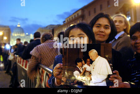 (Dpa) - Kimberly des Philippines montre une photo avec le Pape Jean Paul II bénédiction une femme sur la Place Saint Pierre dans les premières heures du matin, à Rome, Italie, 06 avril 2005. La Basilique St Pierre restera ouvert jusqu'au vendredi 08 avril 2005 pour les personnes en deuil, les visiteurs et les pèlerins du monde entier qui veulent rendre un dernier hommage au Pape Jean Paul II avant est porté en terre Banque D'Images