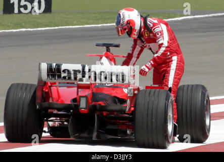 (Afp) - pilote de Formule 1 brésilien Rubens Barrichello (Ferrari) sort de sa voiture après qu'il n'a pas réussi à démarrer pour la deuxième qualification pour le Grand Prix de Bahreïn à la formule une piste près de Manama, Bahreïn, le 3 avril 2005. Banque D'Images