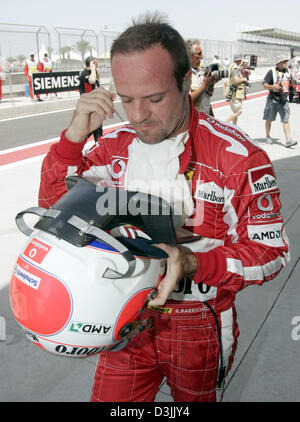 (Afp) - pilote de Formule 1 brésilien Rubens Barrichello (Ferrari) retourne à son puits après qu'il n'a pas réussi à démarrer pour la deuxième qualification pour le Grand Prix de Bahreïn à la formule une piste près de Manama, Bahreïn, le 3 avril 2005. Banque D'Images
