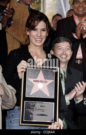 (Afp) - L'actrice Sandra Bullock nous pose pour les photographes en maintenant son prix dans sa main après qu'elle a reçu une étoile sur le Hollywood Walk of Fame à Hollywood, Californie, USA, 24 mars 2005. Banque D'Images