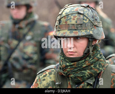 (Afp) - Une femme recruter de la Bundeswehr (armée) se dresse sur un terrain d'entraînement de l'armée à Ahlen, Allemagne, 18 mars 2005. Dans le cadre de leur formation de base, les recrues reçoivent la formation spéciale EAKK qui signifie 'Einsatzausbildung Konfliktverhuetung Krisenbewaeltigung und für' (formation pour la prévention des conflits et la résolution de situations critiques) qui est utilisée pour pré Banque D'Images