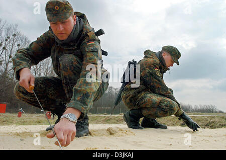 (Afp) - Des recrues de la Bundeswehr (armée) La recherche des mines sur un terrain d'entraînement de l'armée à Ahlen, Allemagne, 18 mars 2005. Dans le cadre de leur formation de base, les recrues reçoivent la formation spéciale EAKK qui signifie 'Einsatzausbildung Konfliktverhuetung Krisenbewaeltigung und für' (formation pour la prévention des conflits et la résolution de situations critiques) qui est utilisé pour p Banque D'Images