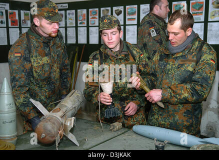 (Afp) - Des recrues de la Bundeswehr (armée) d'examiner divers bombes et roquettes sur un champ d'entraînement de l'armée à Ahlen, Allemagne, 18 mars 2005. Dans le cadre de leur formation de base, les recrues reçoivent la formation spéciale EAKK qui signifie 'Einsatzausbildung Konfliktverhuetung Krisenbewaeltigung und für' (formation pour la prévention des conflits et la résolution de situations critiques) w Banque D'Images