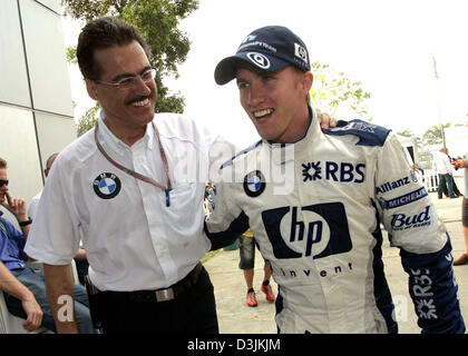 (Afp) - Directeur de BMW Motorsport Mario Theissen (L) félicite l'Allemand pilote de Formule 1 Nick Heidfeld après le Grand Prix de Malaisie à Sepang, près de Kuala Lumpur, Malaisie, le 20 mars 2005. Heidfeld est arrivé en troisième place. Banque D'Images