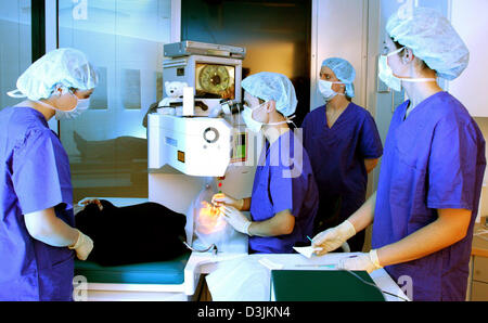 (Afp) - Une équipe de médecins se tenir dans la salle d'opération pendant qu'il effectue la chirurgie sur un patient à l'Hohenzollernklinik -Centre de chirurgie réfractive à Muenster, Allemagne, 27 janvier 2005. Le LASIK est synonyme de Laser-Assisted In Situ Keratomileusis 'en' et se réfère à une procédure chirurgicale sur l'oeil avec un laser excimère destiné à réduire la dépendance à une personne Banque D'Images