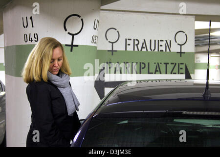 (Afp) - Une femme représentée dans un parking souterrain à côté de sa voiture qui est garé à un emplacement de stationnement qui est réservé aux femmes à Aschaffenburg, Allemagne, le 8 février 2005. Banque D'Images