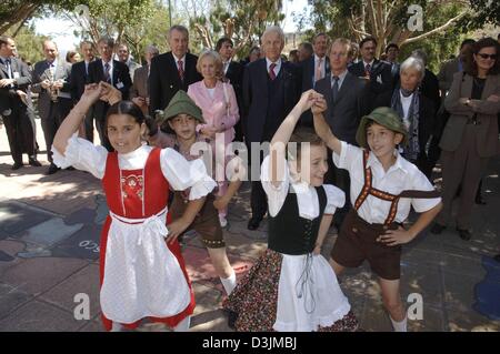 (Afp) - Edmund Stoiber, Premier Ministre de l'état allemand de Bavière, et sa femme Karin regarder les enfants qui sont heureux en gerbes bavarois effectuer une danse traditionnelle lors de leur visite de l'école allemande à Guadalajara, Mexique, le 9 mars 2005. Stoiber semaine de tournée à travers le Mexique (5-9 mars 2005) et en Californie (9-11 mars 2005) porte sur l'extension de la relations économiques Banque D'Images