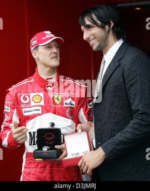 (Afp) - L'Allemand pilote de Formule 1 Michael Schumacher (Ferrari) rencontre Australian médaille d'or olympique de natation Ian Thorpe (R) en tant qu'ils présentent un ensemble de montres sur le circuit du Grand Prix de l'Albert Park, Melbourne, Australie, 05 mars 2005. Banque D'Images