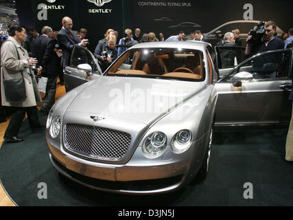 (Afp) - Les visiteurs d'oeil sur le nouveau modèle de vol Continental par constructeur automobile Bentley au 'Autosalon', exposition de voitures, à Genève, en Suisse, le mardi, 01 mars 2005. Les visiteurs peuvent voir les nouveautés dans l'industrie automobile à partir du 03 mars au 13 mars 2005. Banque D'Images