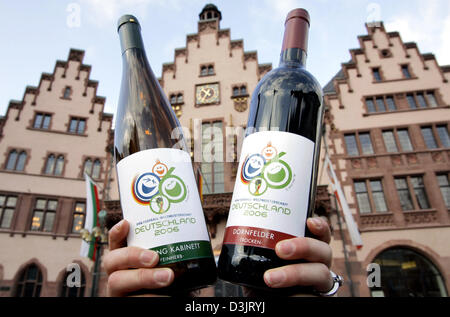 (Afp) - La reine du vin Hochheim détient deux bouteilles de vin pour la première fois officiellement pour la Coupe du Monde de football FIFA 2006 en face de la 'Roemer" (mairie) de Francfort à Francfort, Allemagne, 19 janvier 2005. Au cours d'une conférence de presse le vignoble de la ville a présenté les premières bouteilles doté du logo de la FIFA à la Coupe du Monde de la conception à la presse. Banque D'Images