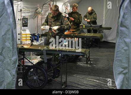 (Afp) - l'armée du personnel paramédical (L-R) Le Master Sergeant Gerhard Haben et les sergents d'Ingo Abel et Steffen Kraemer préparer leur équipement dans une nouvelle infirmerie gonflable tente pour le transport jusqu'à la zone de la catastrophe en Indonésie à Varel, Allemagne, le 3 janvier 2005. L'aide médicale pour le déploiement dans les régions en crise proviennent de l'armée de terre allemande med déploiement rapide Banque D'Images