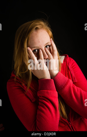 Un timide 16 nerveux, 17 ans, aux cheveux rouges de rousseur face adolescente, UK Banque D'Images