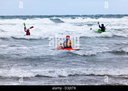 Un homme attend dans les vagues déferlantes à Black Rock Beach, Widemouth Bay nr, Bude, Cornwall, UK Banque D'Images