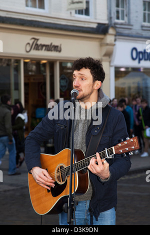 Les Amuseurs publics titulaires d'  Neil Ryan un musicien singing into microphone, aux spectacles de rue dans le centre de York, Yorkshire, UK Banque D'Images