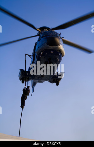 Forces spéciales (SWAT) membre en ordre décroissant sur la corde d'un hélicoptère (un fait français AS 332 Super Puma L1 Eurocopter) Banque D'Images