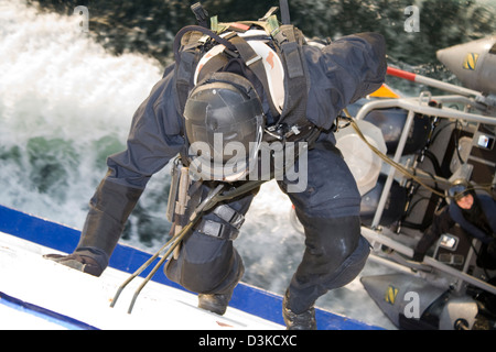 Une des forces spéciales (SWAT) repousse l'agent en bas du côté d'un navire en mouvement d'un bateau. Banque D'Images