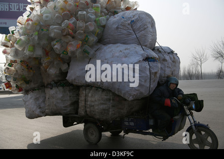 Un tricycle à moteur chargé avec des bouteilles en plastique recyclable durs le long d'une rue dans une ville dans la province de Hebei, Chine. 17-Feb-2013 Banque D'Images